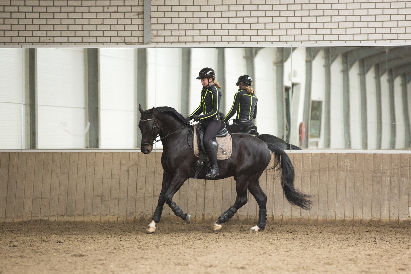 Sanne en Lincoln rijden in de binnenbak langs een spiegel