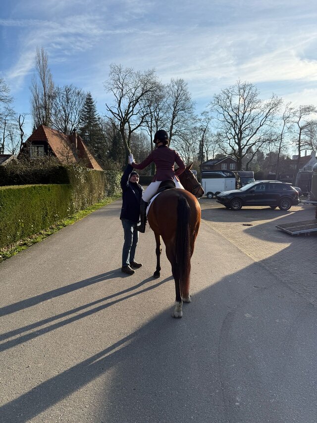 elise van rooijen geeft highfive aan vader vanaf paard