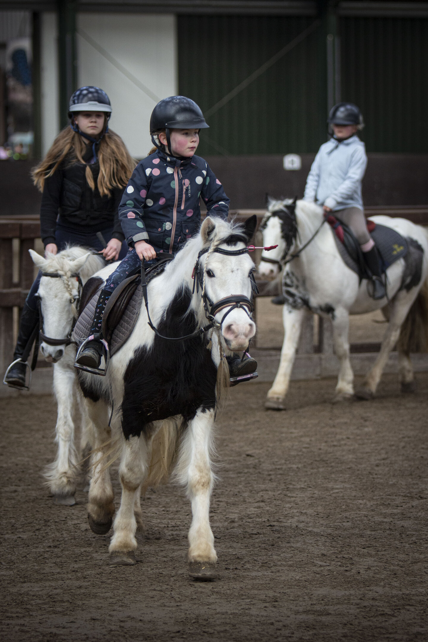een kindje rijdt geconcentreerd met haar pony