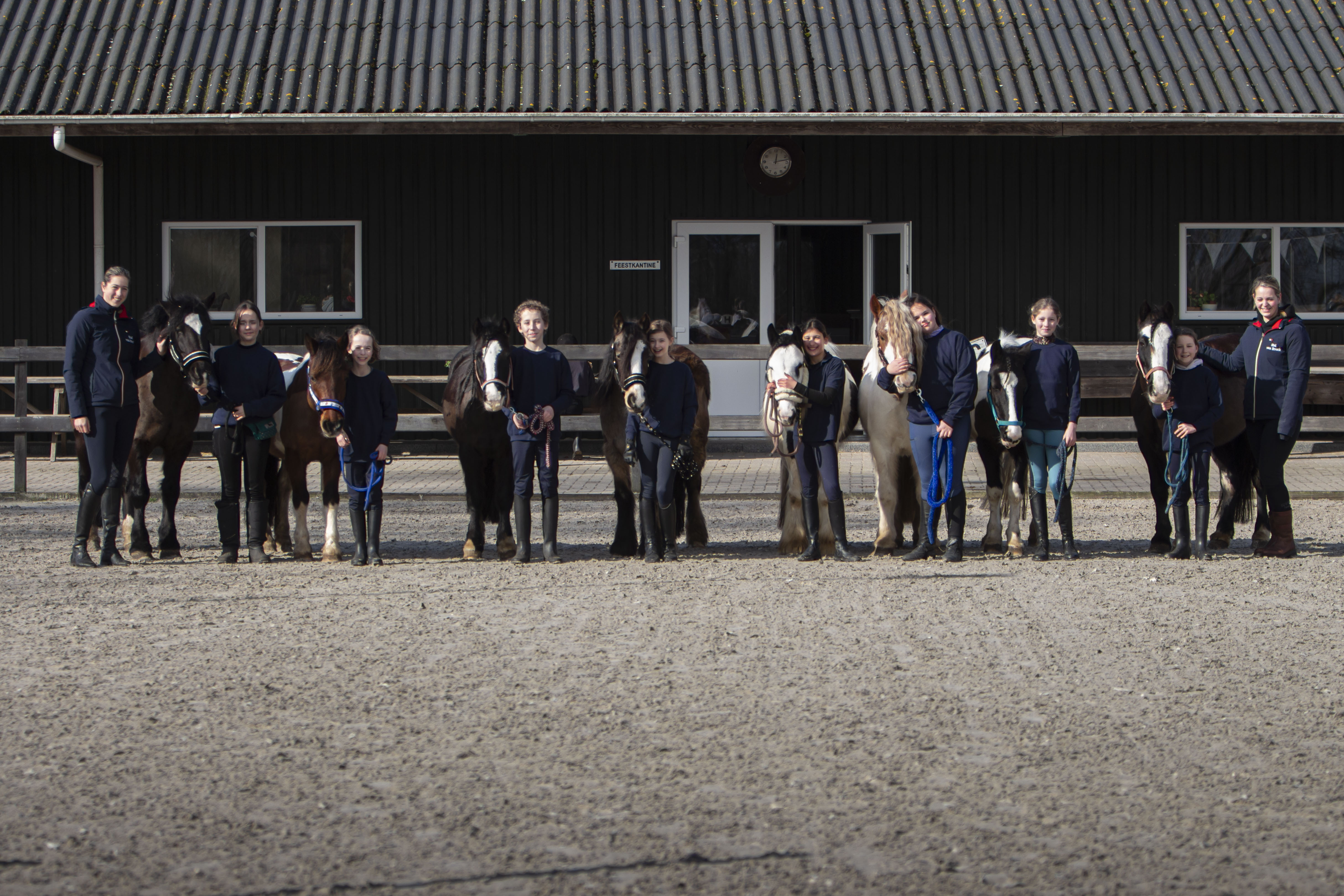 een groep kinderen poseert met de pony voor de carmera