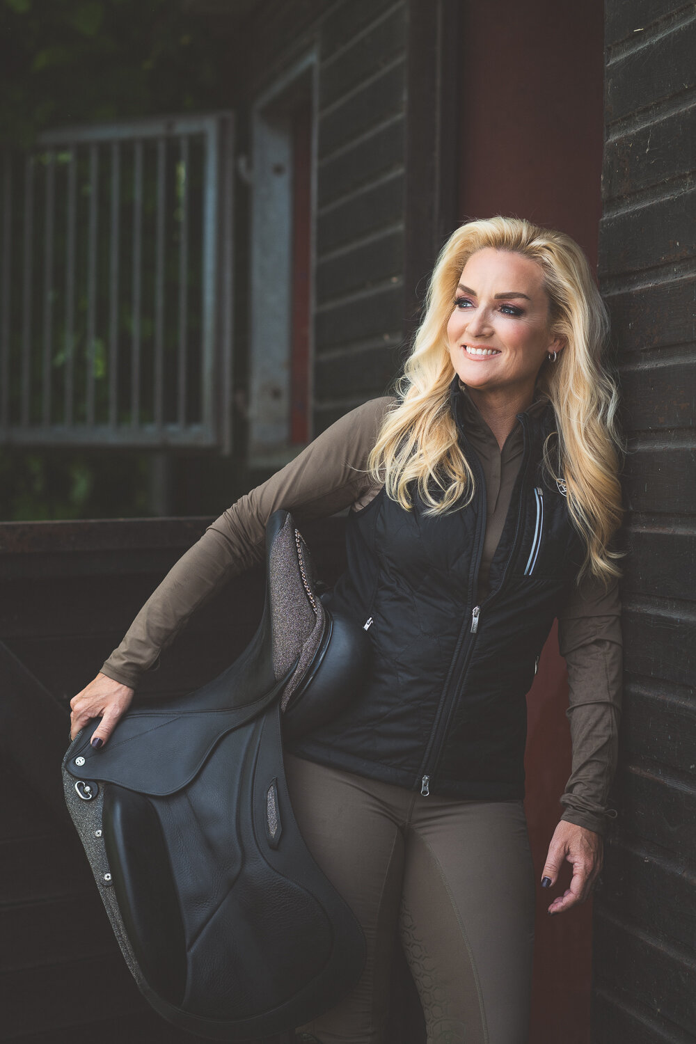 Samantha poseert bij stal met haar zadel
