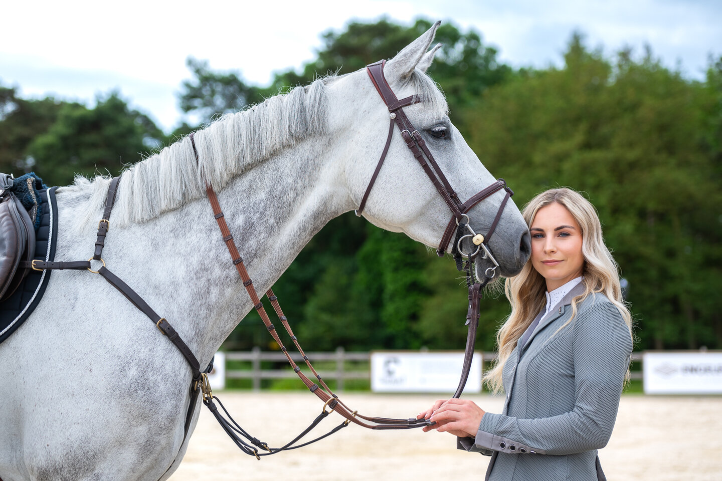 Blond model poseert naast een schimmel met springuitrusting