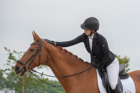 Marisa beloont haar paard na het rijden
