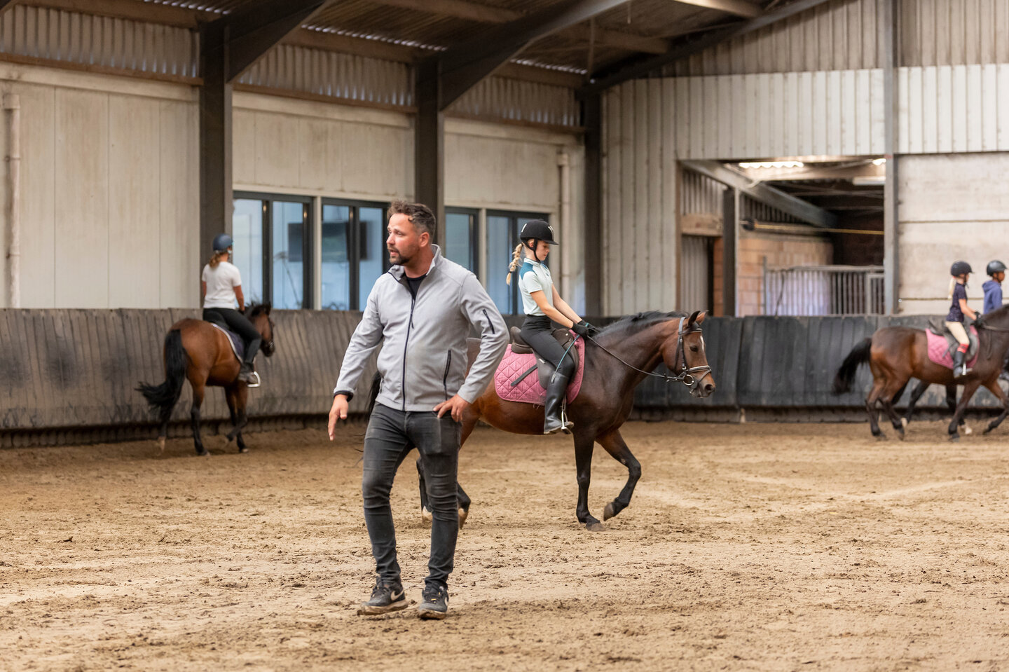 manegehouder yorick staat in het midden van de bak tijdens het lesgeven