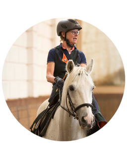 zoë staat met haar rug naar de lezer en tuurt in de verte naar een pony in de paddock