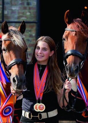 dinja van liere juicht terwijl ze op hermes zit, na het winnen van de nederlandse titel